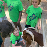 Camp Venture participants at a petting zoo with a billy goat