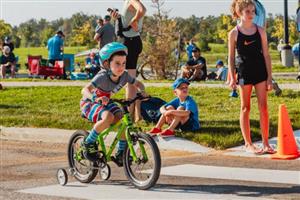 Youth biking with training wheels